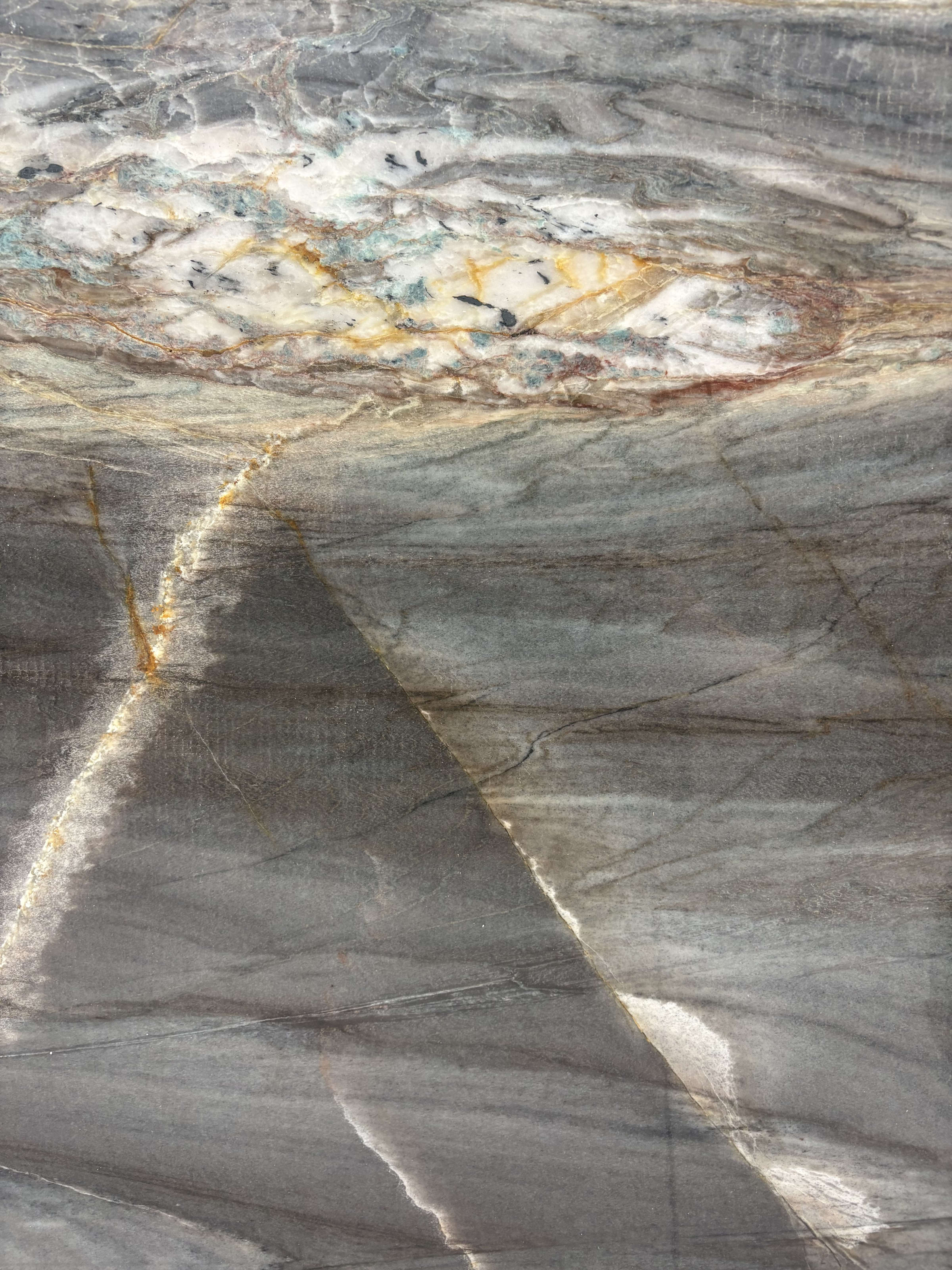 Ocean Blue quartzite detail, charcoal-grey movement with a crystalline pocket of gold and blue