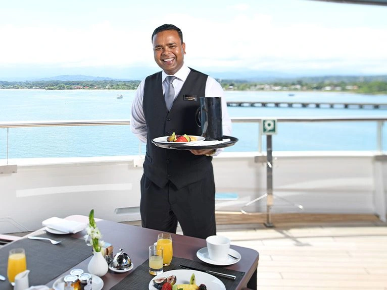 Butler serving breakfast on a private deck
