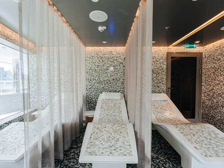Salt therapy lounge with mosaic-tiled heated loungers