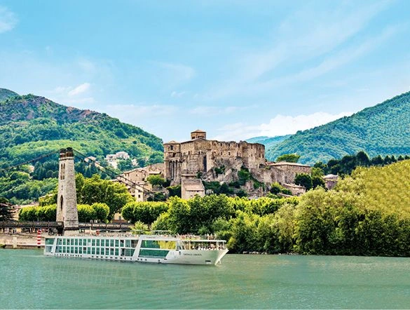 Luxury river ship sailing the Rhône River past an ancient castle in the South of France