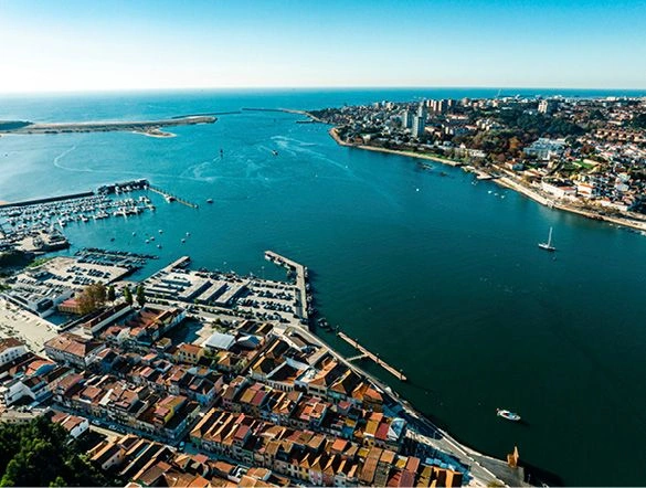 alt="A landscape view of the city of Porto, Portugal, with the Atlantic Ocean in the background."
