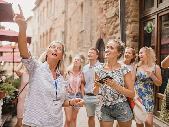 Group of people listening to an expert guide whilst enjoying a tour in the streets of a Mediterranean town