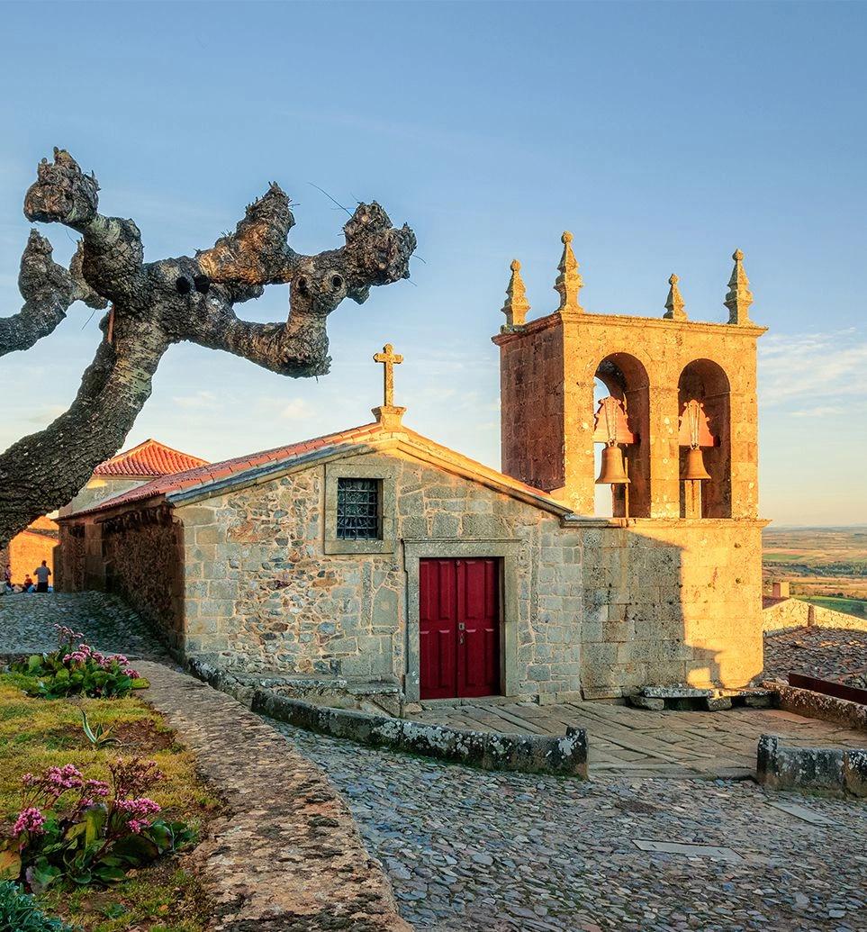 Stone chapel and bell tower in Castelo Rodrigo at sunset