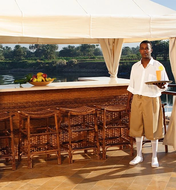 Crew member serving a drink at Sanctuary Sun Boat III’s outdoor bar