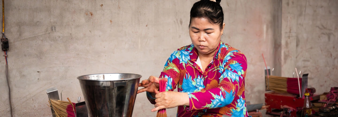 Artisan bundles incense sticks in a workshop on Gieng Island