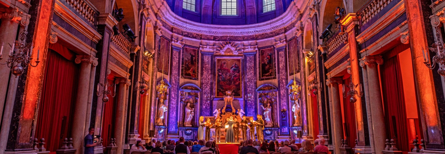 Guests attend a Scenic Enrich concert inside a vividly lit Trinity Chapel