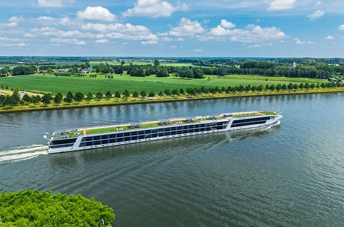 Emerald Astra sailing past green countryside in the Netherlands