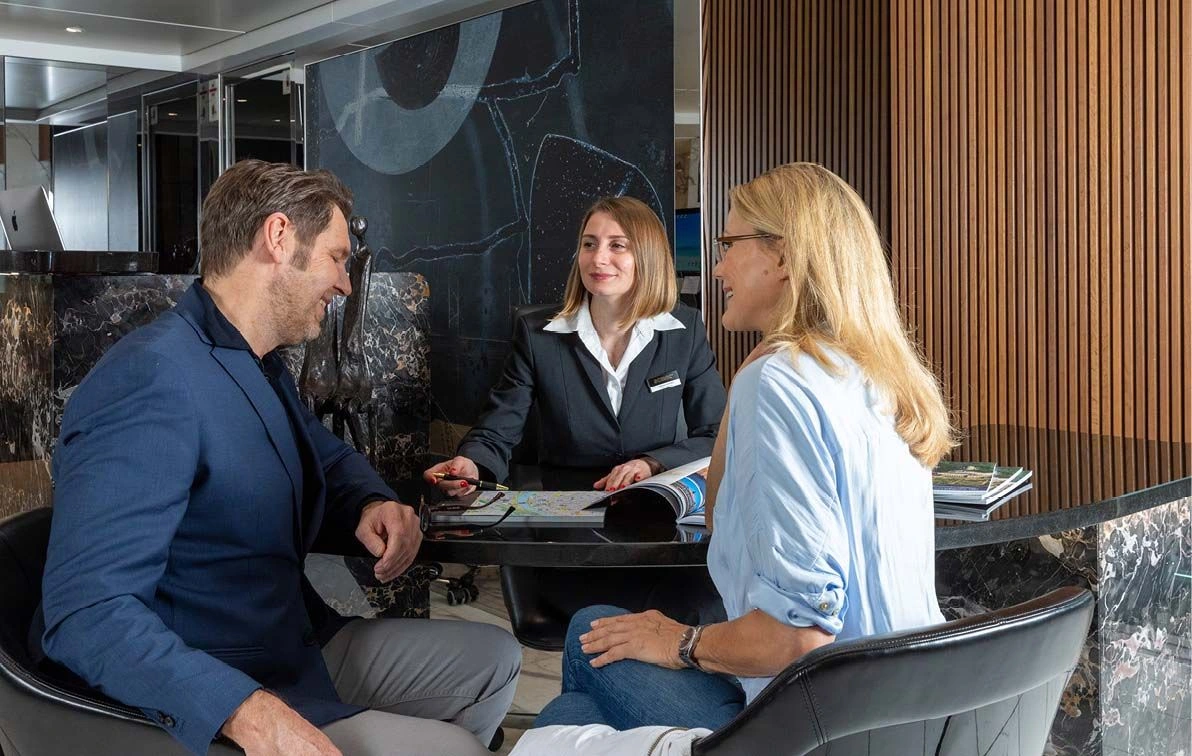 Cruise director talking to two people