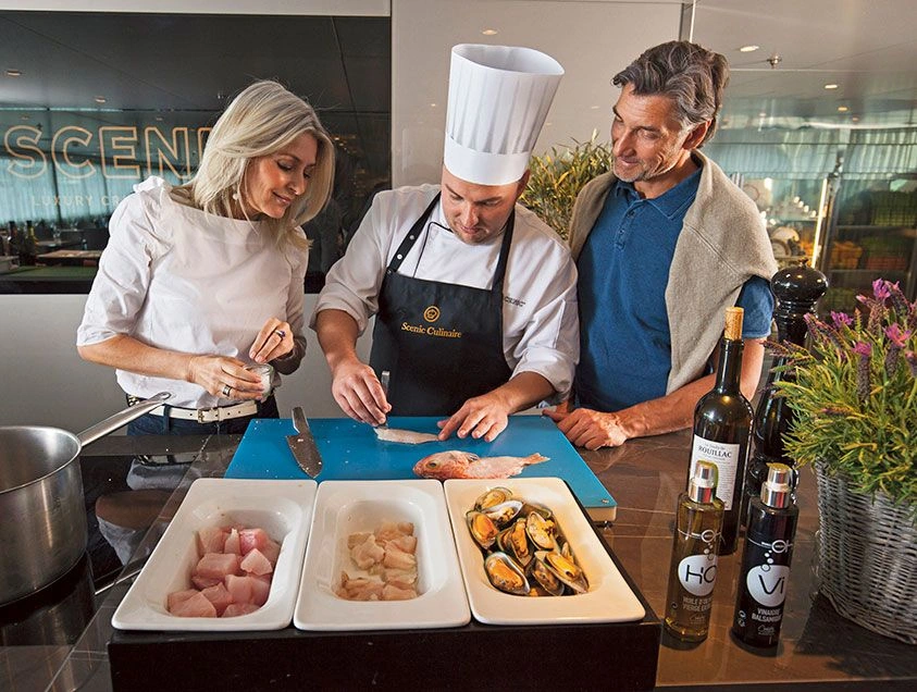 Guests cooking with a Chef during a Scenic Culinaire masterclass on a France river cruise