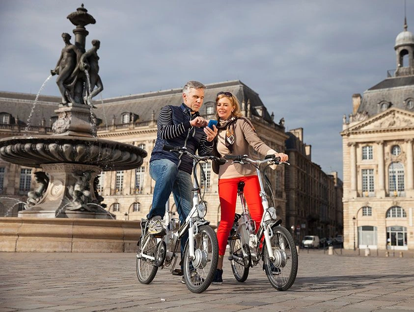 A man and woman riding e-bikes in Europe