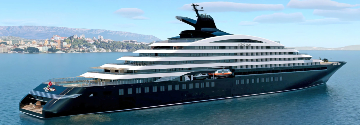 Scenic Ikon Discovery Yacht at anchor beside a coastal city