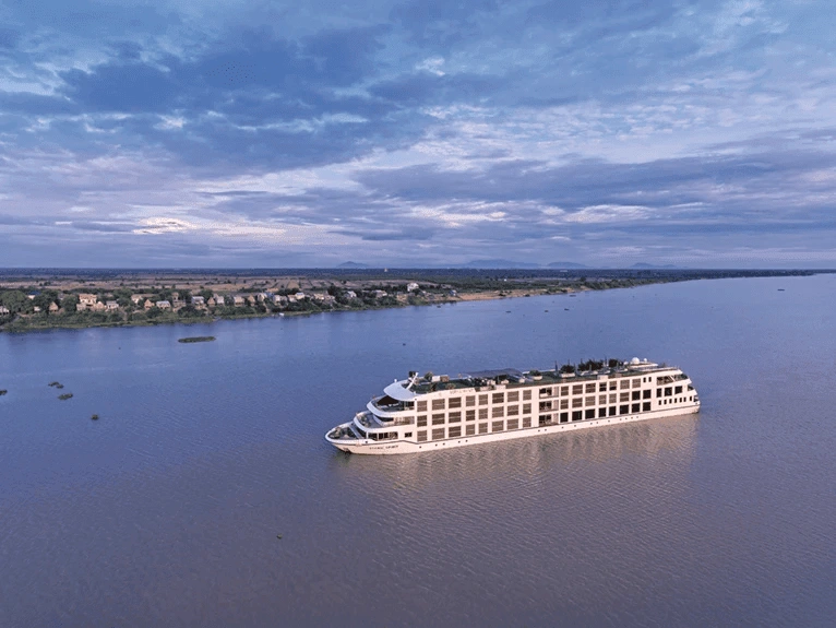 The Scenic Spirit ship sailing on the Mekong River, under a sky with hues of blue and purple.