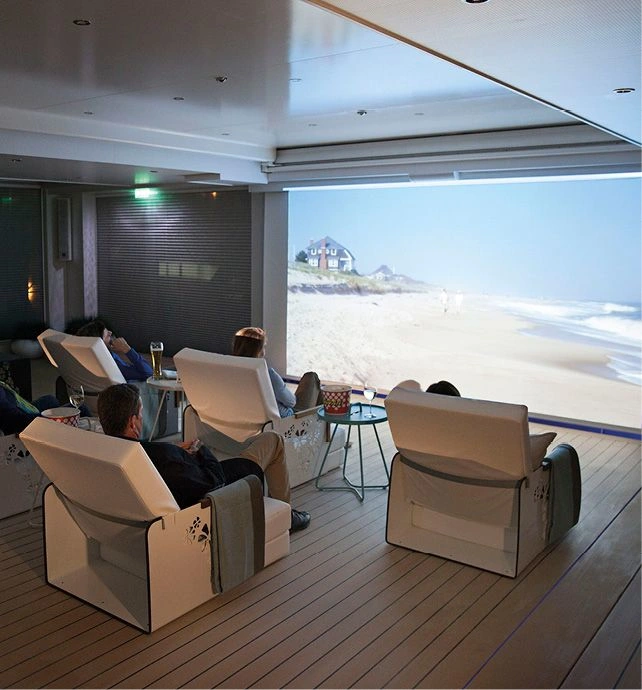 Innovate cinema space with lounge seating and guests enjoying a sunny beach scene