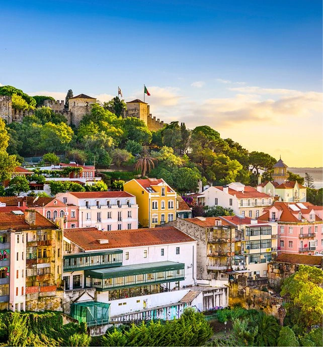 A bright blue sky is seen over Lisbon’s colourful buildings with the 25th April Bridge seen in the background.
