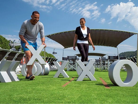 Friends playing a game of noughts and crosses on the Sun Deck of a luxury river ship on a bright day