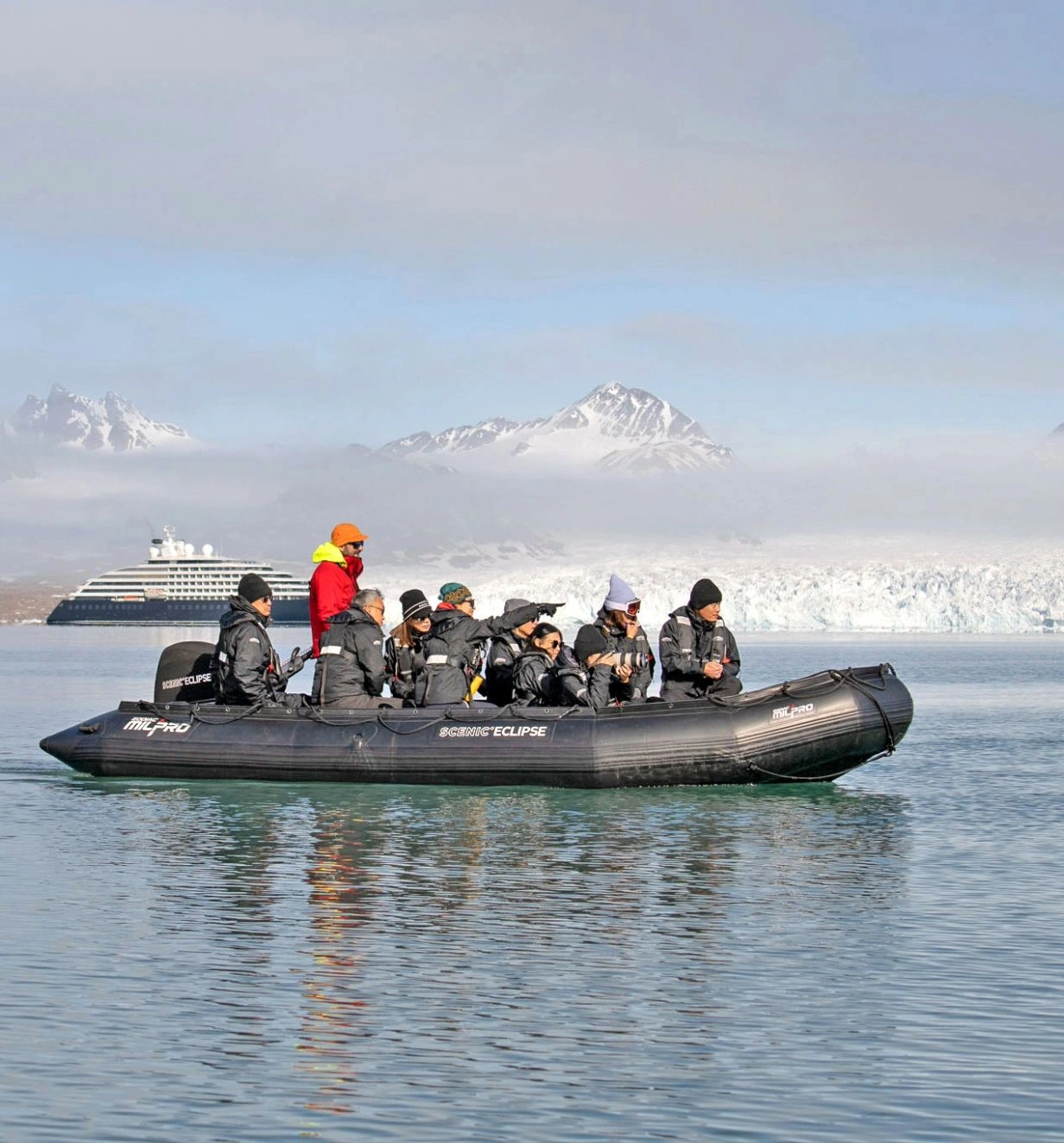 A group of travellers on board a blow up speed boat surrounded by icy waters. 