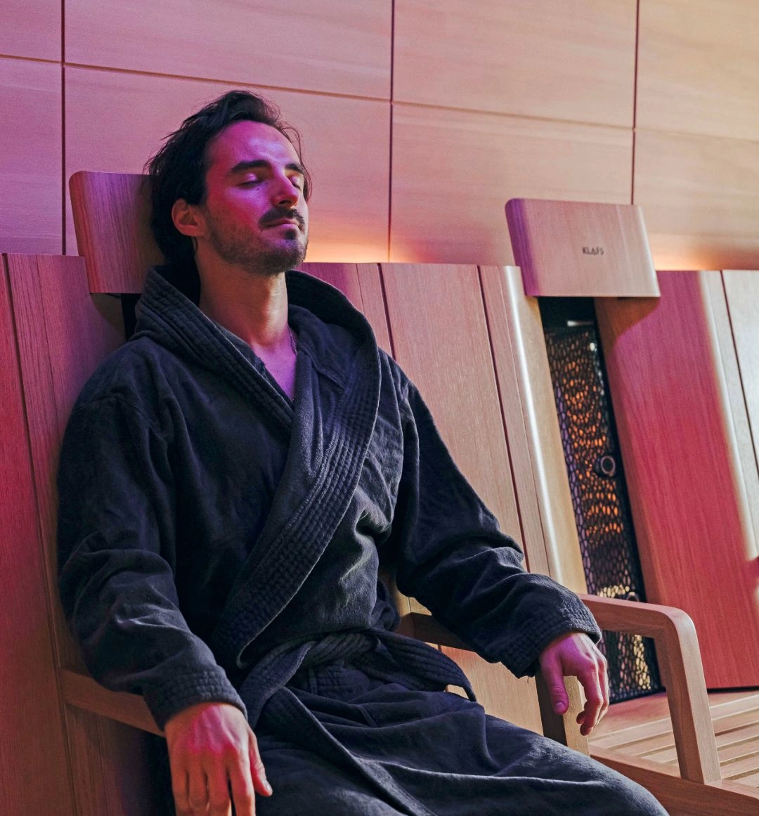 Man relaxing in ambient lit spa room