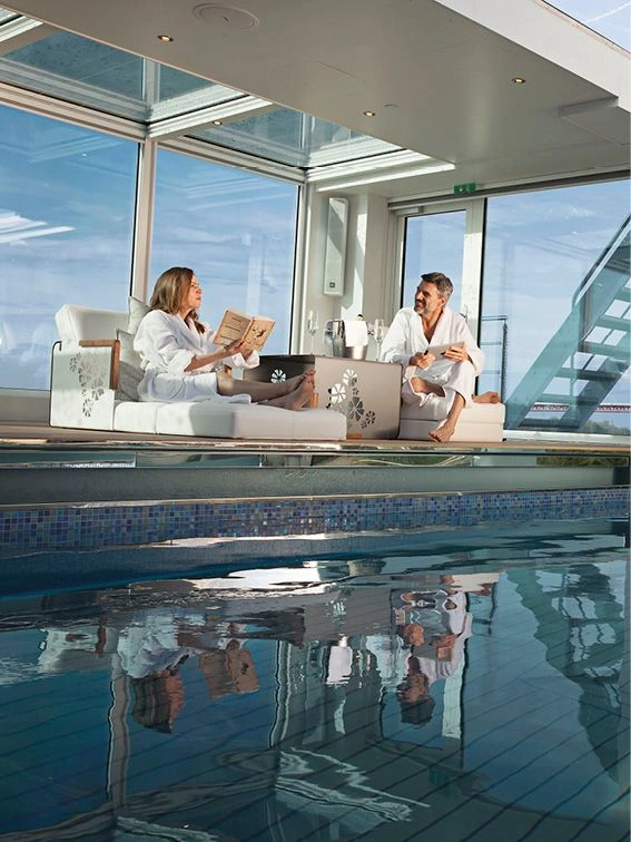 Two guests enjoying a relaxing day by the pool on board a luxury river ship