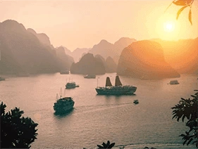 Boats on the water at sunset in Halong Bay, Vietnam