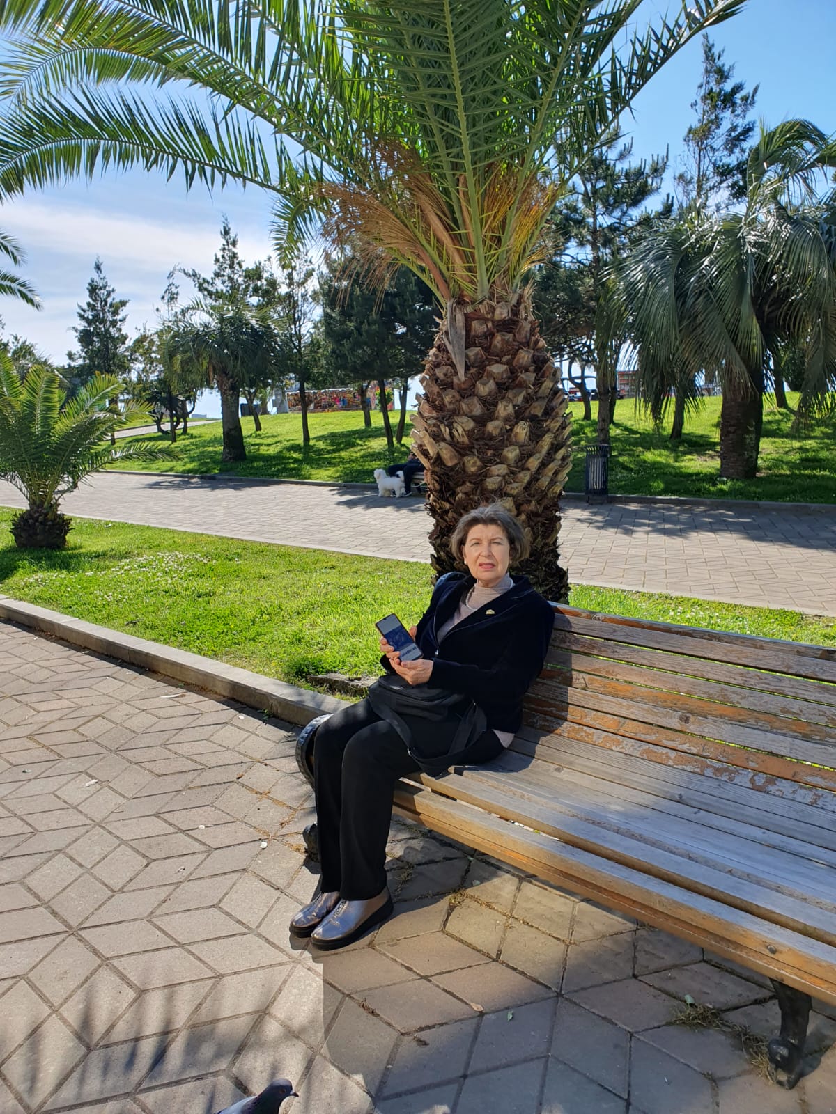 Виктория Диасамидзе сидя на скамейке в парке.