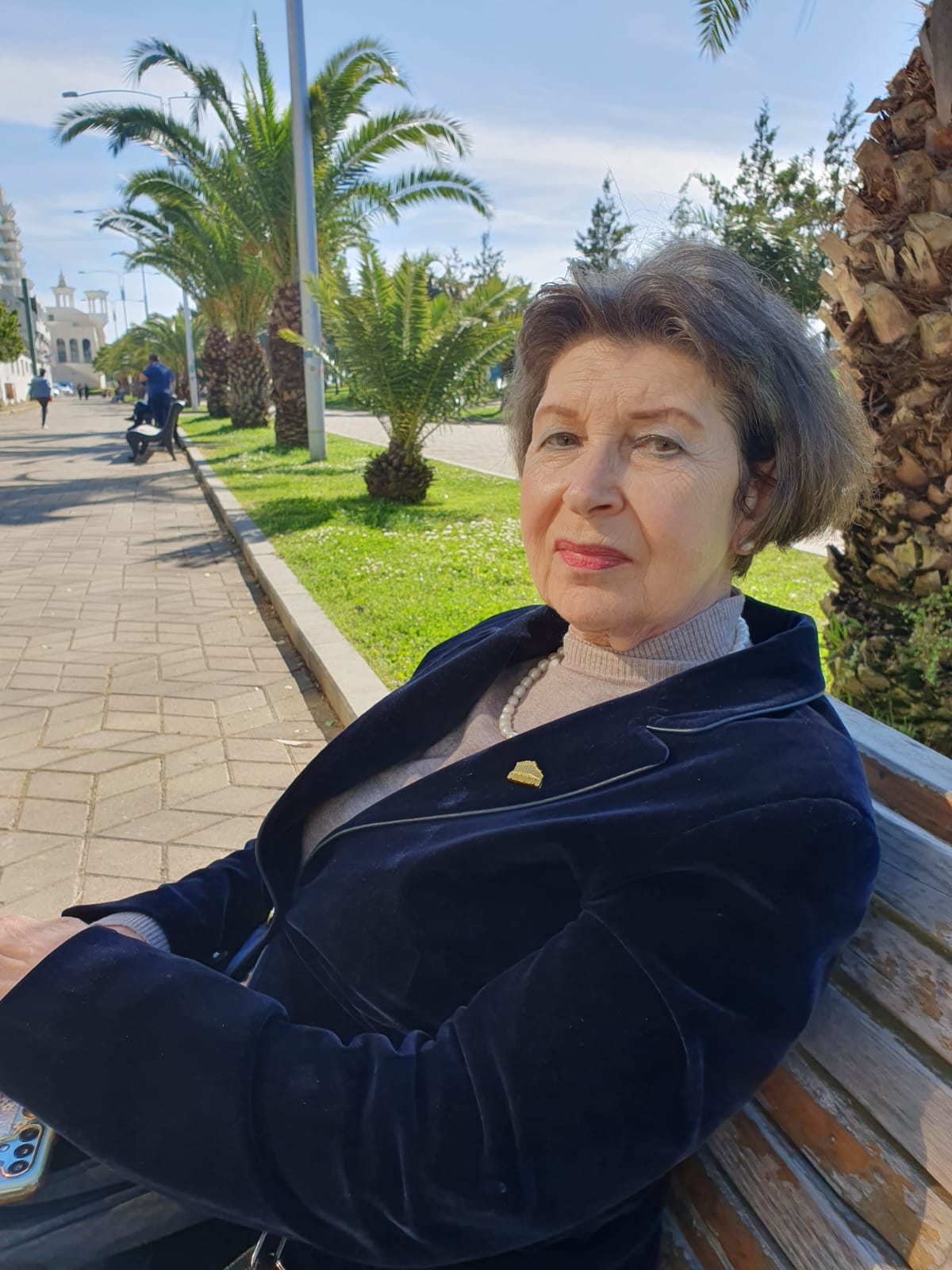 Виктория Диасамидзе сидя на скамейке в парке.