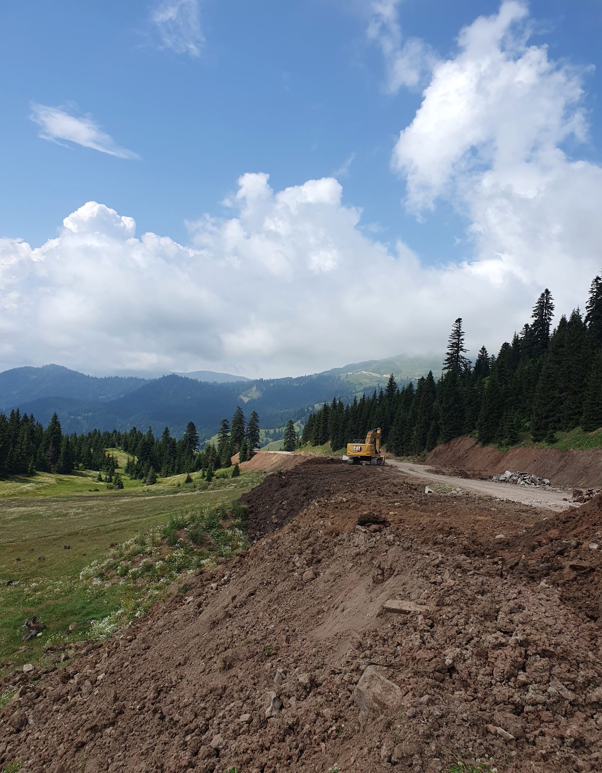 экскаватор выравнивает дорогу