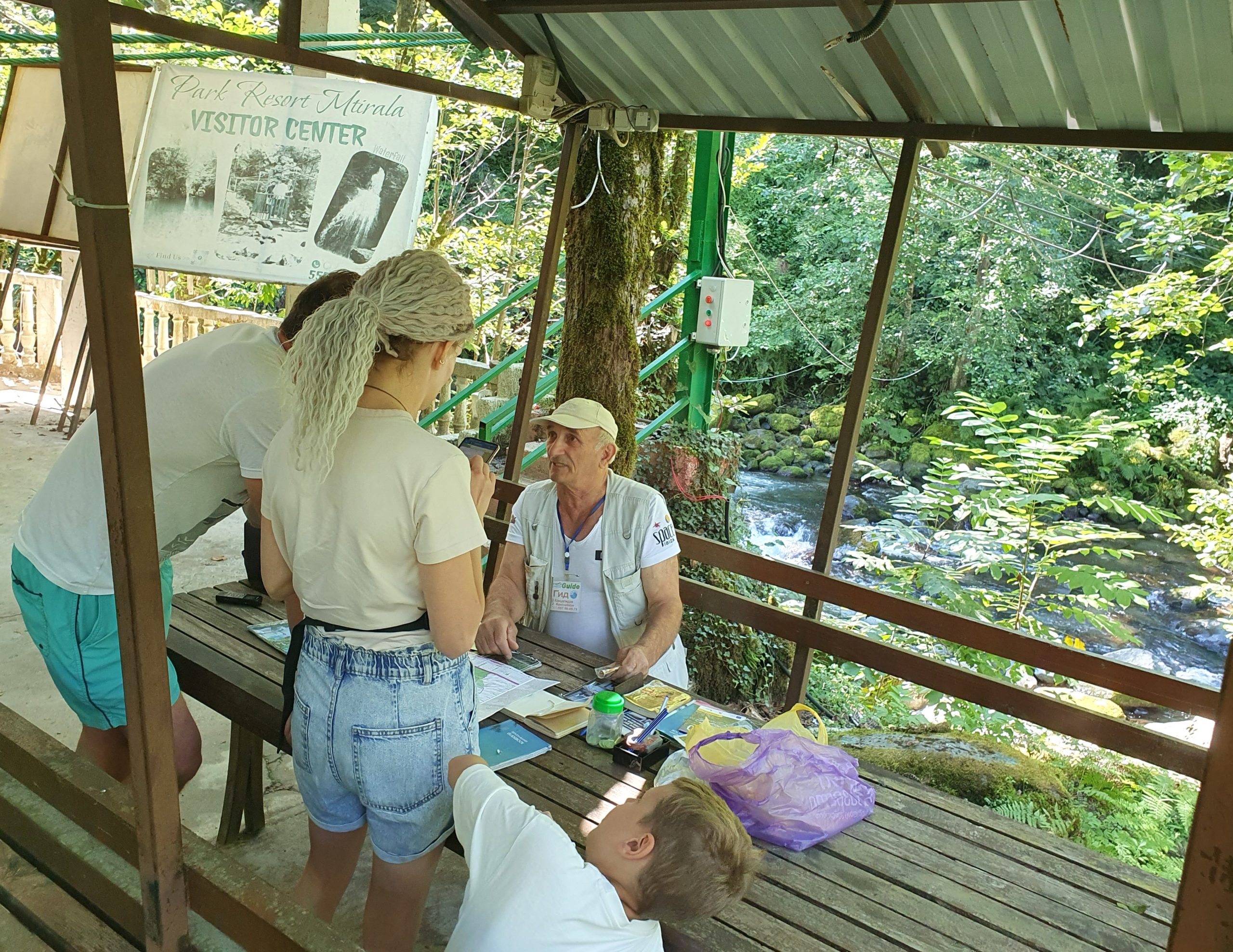 Гид Зорбек Конселидзе беседует с посетителями в беседке