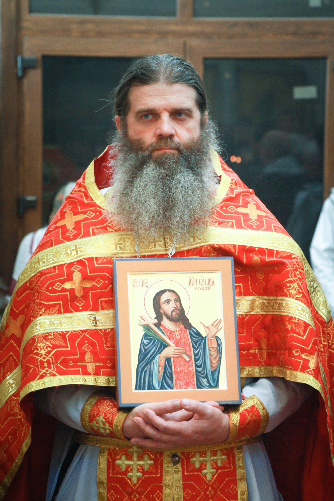 Отец Иоанн держит икону