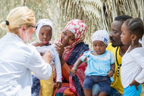 Nurse on medical mission trip to Africa examines family members.