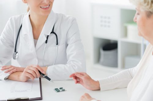An FNP discusses medication with a patient.