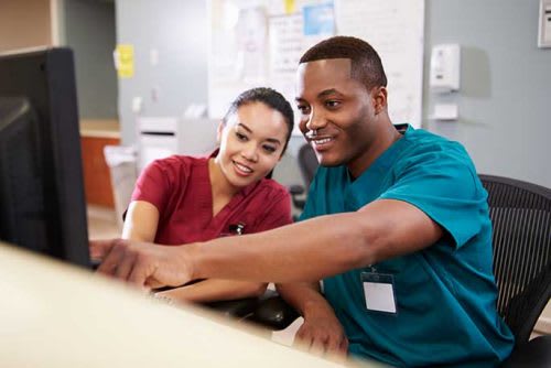 2 people looking at a computer monitor