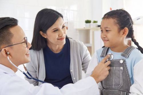 Nurse practitioner treating a child patient.