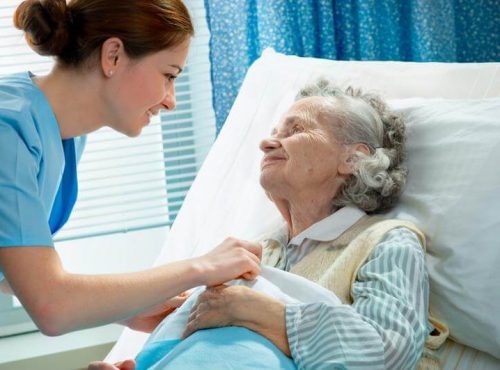 Nurse in hospital room speaking with patient