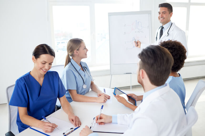 A DNP nurse educator teaches a class of nursing students. 