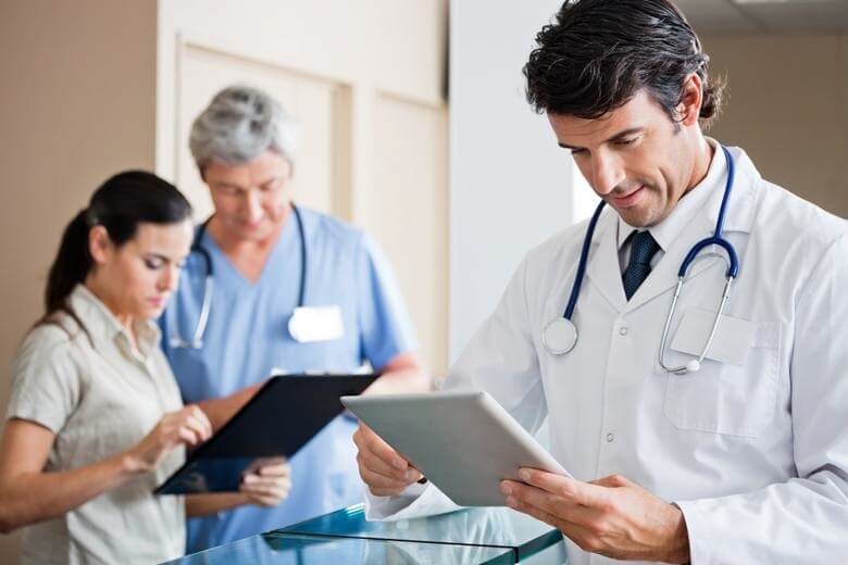 Three medical professionals using tablets