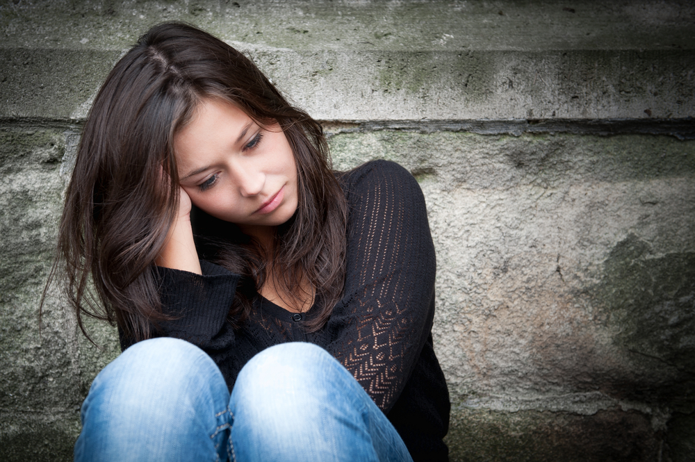 Withdrawn woman sitting alone.
