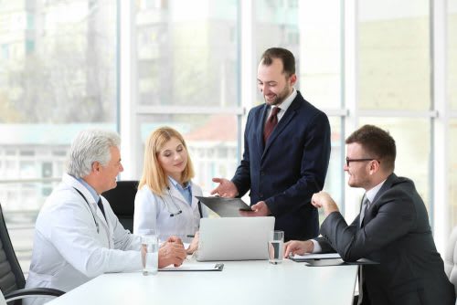 Health care executives talk during a meeting.