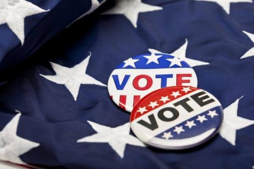 ‘Vote’ buttons laid on the American flag.