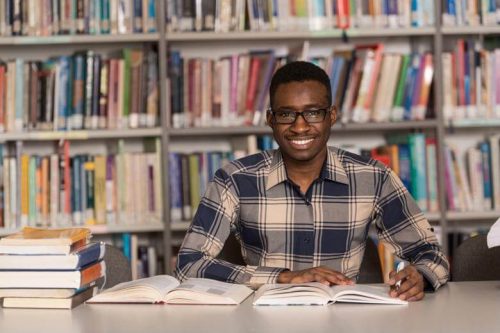 An online MSN-FNP student studies in his local library.