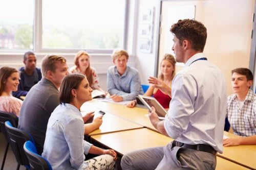 A counselor leads a group workshop for college-bound high schoolers.