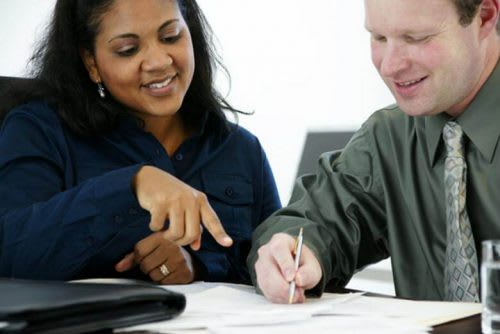 A college career counselor helps a student edit a resume.