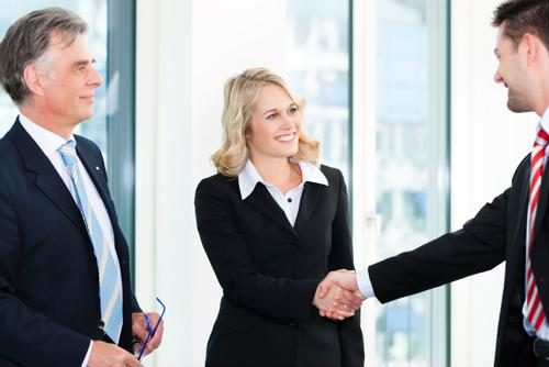 A doctor of nursing practice greets two hospital administrators.