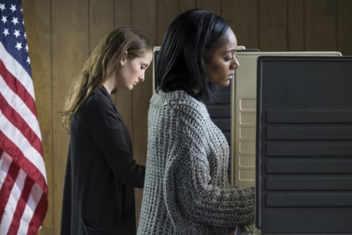 Women at separate voting booths.