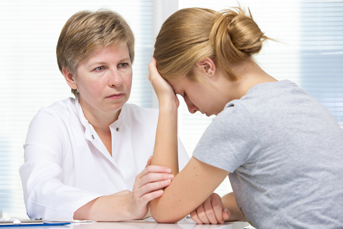 A family nurse practitioner consoles a patient.