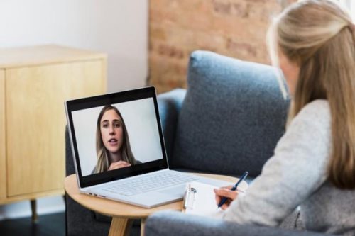 A counselor meets with a patient via video call.