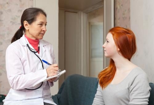A doctor of nursing practice speaks with a female patient.