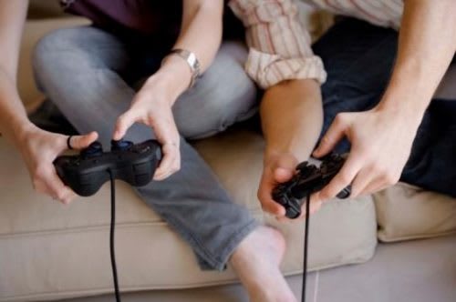 Two teenagers hands holding gaming consoles while playing video games
