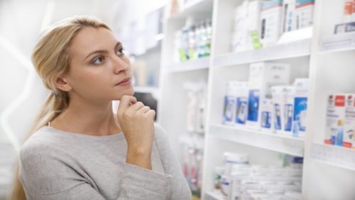 A consumer looks at items on a store shelf.