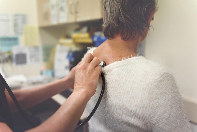 A nurse listens to a patient’s heart beat.
