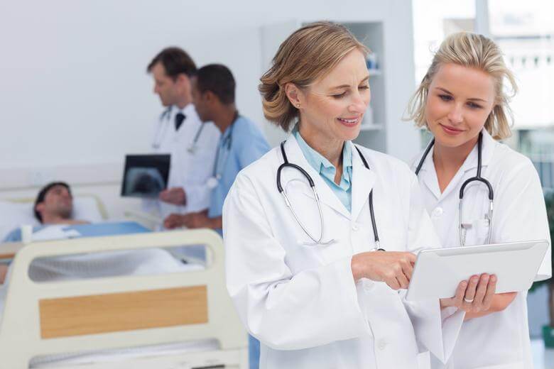 Female Doctor in a White Coat and Stethoscope Around the Neck Discussing Patient's Results With a Colleague